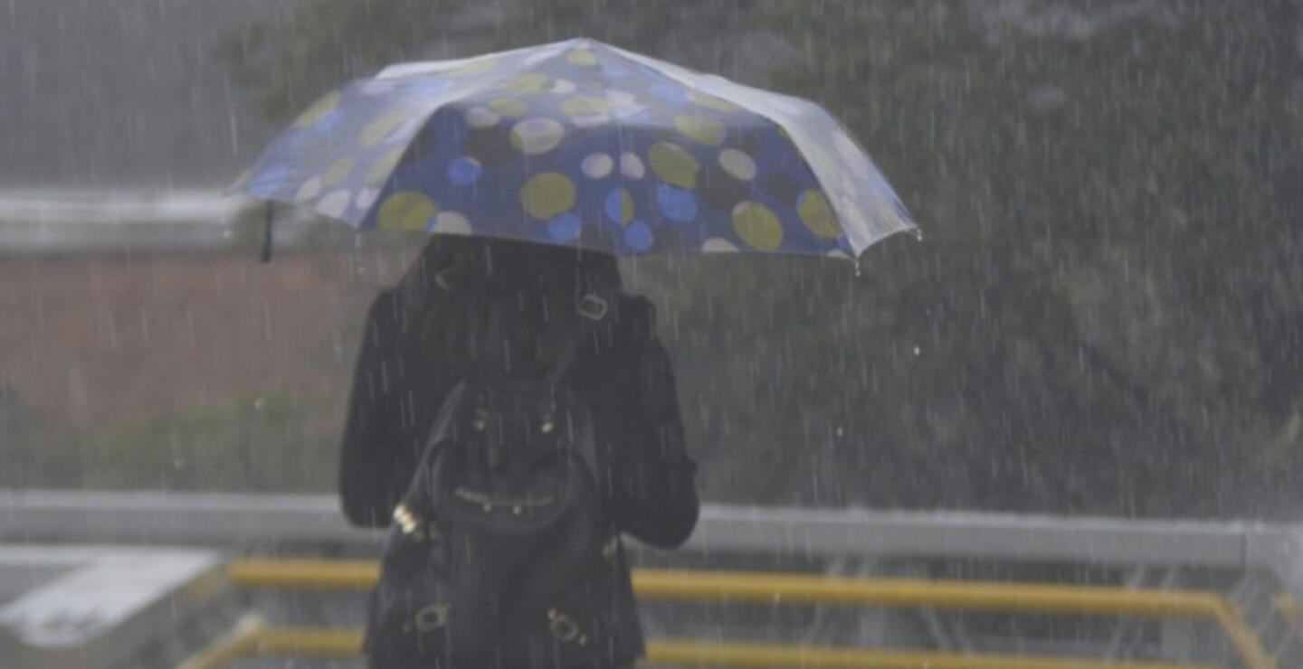 Mujer con sombrilla bajo la lluvia en Bogotá. 