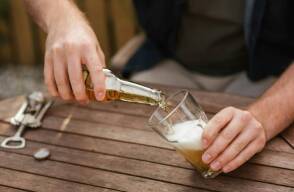 Hombre sirviendo una cerveza fría en un vaso.