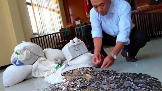11301_La Kalle. Dwi Susilarto, indonesio que pagó con monedas a su exesposa. Foto AFP 11301_La Kalle. Dwi Susilarto, indonesio que pagó con monedas a su exesposa. Foto AFP