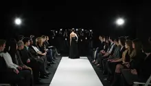 Model in gown at end of catwalk posing