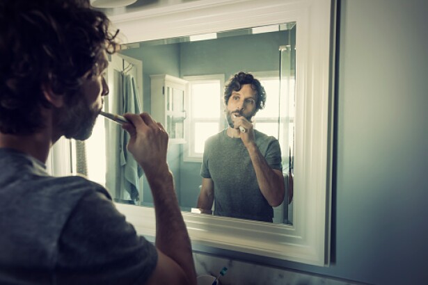 Imagen de referencia, hombre utilizando un cepillo dental.
