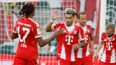 Luis Díaz junto a Michel Olise en medio de una celebración de gol con Bayern Múnich. 