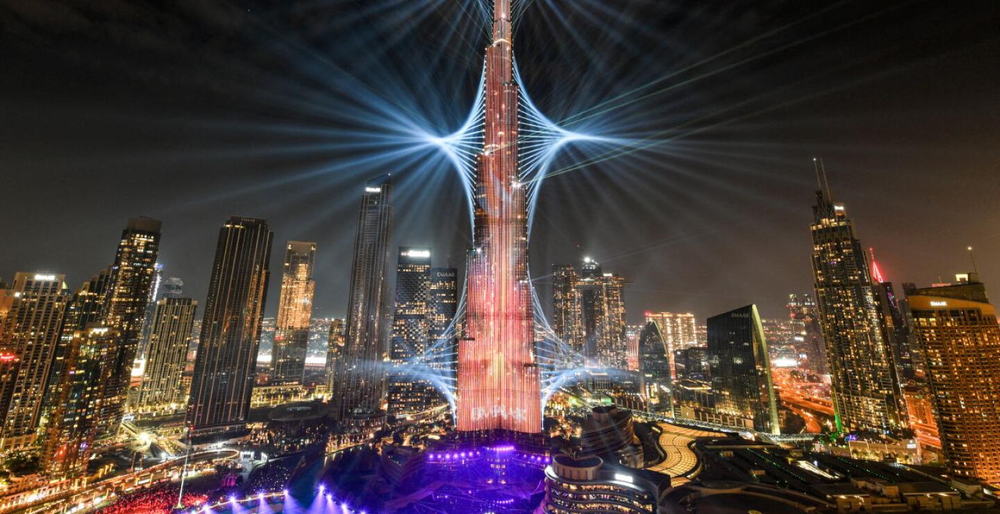 El emblemático rascacielos Burj Khalifa, el edificio más alto del mundo, se ilumina en Dubái a medianoche en la víspera de Año Nuevo el 1 de enero de 2024.