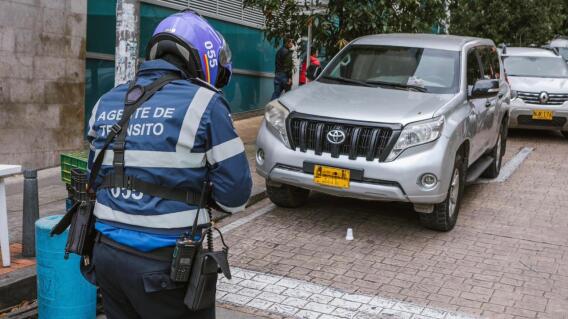 Agente de tránsito imponiendo un comparendo a un vehículo por mal parqueo. Agente de tránsito imponiendo un comparendo a un vehículo por mal parqueo.
