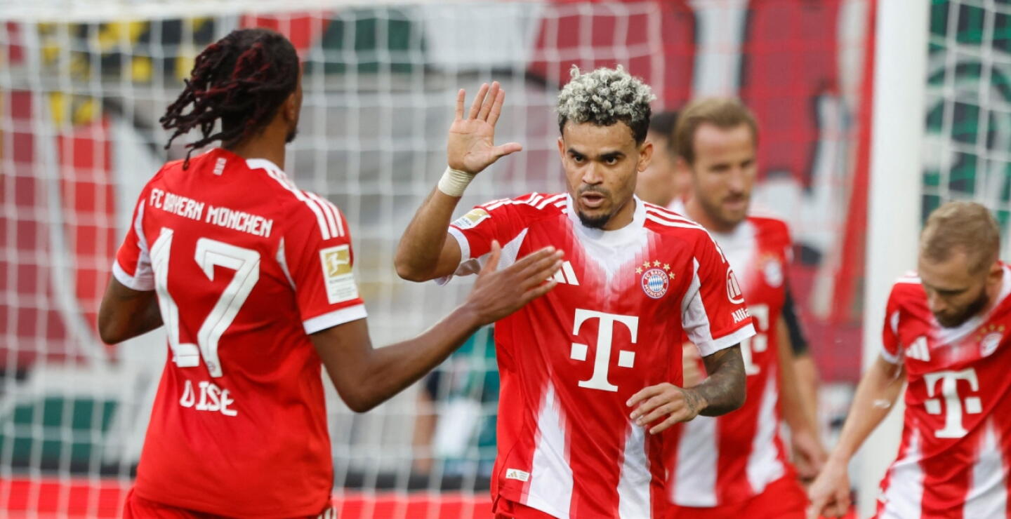 Luis Díaz junto a Michel Olise en medio de una celebración de gol con Bayern Múnich. 
