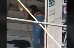 Vendedora de zapatos agrandando calzado con un palo de escoba