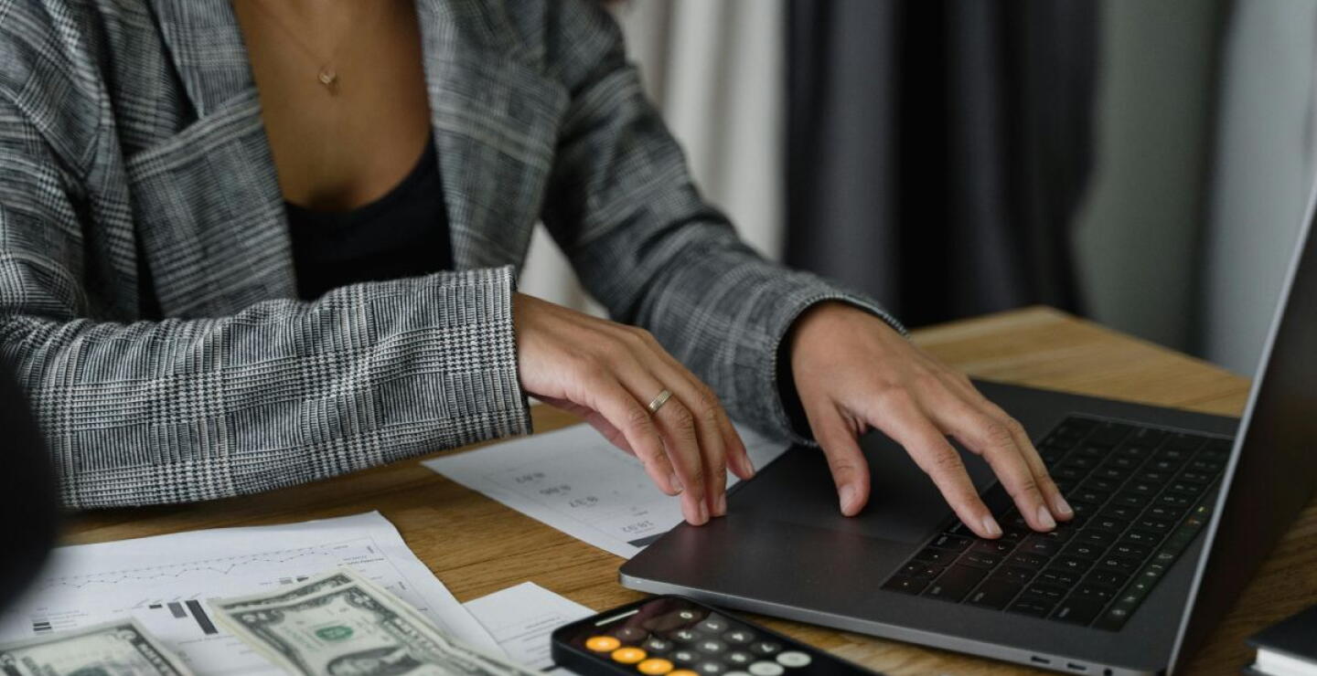 Contadora sentada en el escritorio, realizando su trabajo frente al computador. 