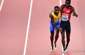 344598_Un atleta agotado llega a la meta sostenido por un rival / Foto: AFP