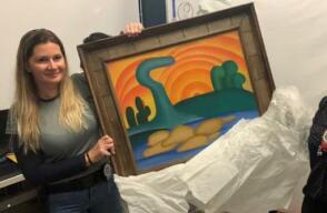 Policías sostiene pintura recuperada "Sol Poente" de la artista brasileña Tarsila do Amaral.