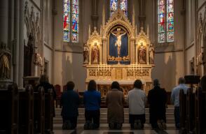 Personas orando en el altar de la iglesia ante Jesucristo