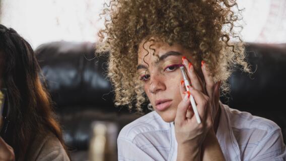 Teenage girl applying eyeliner with a brush Teenage girl applying eyeliner with a brush