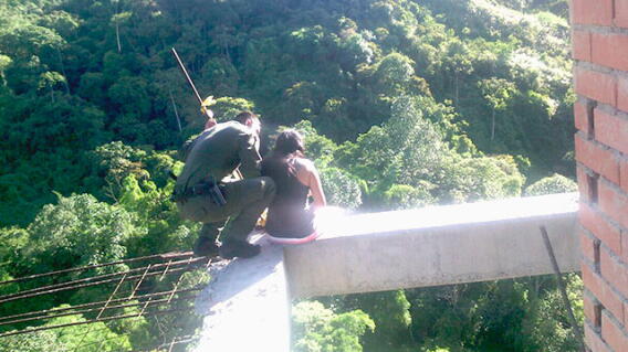 Momento en que un patrullero de la Policía convence a una mujer de no arrojarse al vacío. Foto: Alcaldía de Envigado.