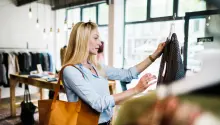 Woman Reading Label On Clothing While Out Shopping