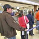 Personas haciendo fila en un banco mientras esperan ser atendidos.